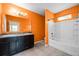 Orange bathroom featuring double sinks and a tub-shower combo with tiled walls at 2193 Betsy Ross Ln, St Cloud, FL 34769