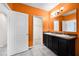 Bright orange bathroom boasts double vanity and open doorway to another room at 2193 Betsy Ross Ln, St Cloud, FL 34769