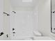 Bathroom featuring a shower-tub combination with white tile surround and black fixtures at 2301 Finwick Ct, Kissimmee, FL 34743