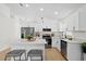 Bright, white kitchen featuring stainless steel appliances, an island with seating, and quartz countertops at 2301 Finwick Ct, Kissimmee, FL 34743