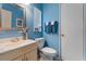 Cozy bathroom with blue walls, a vanity, a toilet, and natural light through the window at 2904 Allison Dr, Orlando, FL 32826