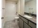 Bathroom featuring a granite vanity, tiled floors, and a shower-tub combo with white tiling at 4326 Sagefield Dr, Harmony, FL 34773