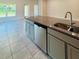 Kitchen island featuring gray cabinets, granite countertops, and a stainless steel dishwasher at 4326 Sagefield Dr, Harmony, FL 34773