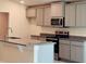 Updated kitchen with gray cabinets, granite countertops, and stainless steel appliances at 4326 Sagefield Dr, Harmony, FL 34773