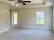 The main bedroom features neutral carpet, a ceiling fan, a tray ceiling, and lots of natural light at 4326 Sagefield Dr, Harmony, FL 34773