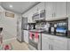 Modern kitchen featuring stainless steel appliances, white cabinets, and sleek black countertops at 4740 Walden Cir # 28, Orlando, FL 32811