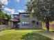 A spacious backyard featuring lush green grass, trees, and a covered patio area at 5107 Appenine W Loop, St Cloud, FL 34771