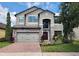 Charming two-story home with stone accents, landscaped yard, and brick-paved driveway at 5107 Appenine W Loop, St Cloud, FL 34771