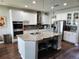 Modern kitchen with white cabinets, stainless steel appliances, and a large island with seating at 5107 Appenine W Loop, St Cloud, FL 34771