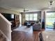 Spacious living room boasts hardwood floors, ceiling fan, comfortable gray sectional, and view to the backyard at 5107 Appenine W Loop, St Cloud, FL 34771