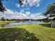 Scenic view of a tranquil pond with a fountain and green grassy shoreline at 5107 Appenine W Loop, St Cloud, FL 34771