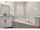 Bright bathroom featuring a soaking tub with tile surround and vanity at 5365 Bowman Dr, Winter Garden, FL 34787