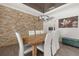 Dining room with a wood table, modern chandelier, stone wall, and wood flooring; ample seating for Gathering at 5365 Bowman Dr, Winter Garden, FL 34787