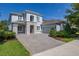 Charming two-story home with a paver driveway, stone accents, well-manicured landscaping and blue skies at 5365 Bowman Dr, Winter Garden, FL 34787
