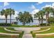 Stunning lake view with palm trees and a private boat dock, providing a tropical and luxurious waterfront living experience at 5365 Bowman Dr, Winter Garden, FL 34787