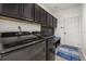 Modern laundry room featuring sleek black washer and dryer, built-in storage, and convenient bench at 5365 Bowman Dr, Winter Garden, FL 34787
