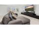 Inviting living room with a gray sectional, bright windows, and a sleek entertainment setup for comfortable relaxation at 5365 Bowman Dr, Winter Garden, FL 34787