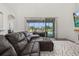 Spacious living room featuring a large sectional sofa and an inviting view of the outdoor pool at 5365 Bowman Dr, Winter Garden, FL 34787