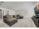 Spacious living room featuring a comfortable gray sectional sofa, plush carpeting, and abundant natural light from the windows at 5365 Bowman Dr, Winter Garden, FL 34787