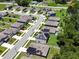 This aerial view shows the neighborhood streets with some homes equipped with solar panels at 6780 Coral Berry Dr, Mount Dora, FL 32757