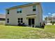 Exterior view of a house with a well-maintained backyard and a covered patio area at 6780 Coral Berry Dr, Mount Dora, FL 32757