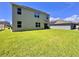 Spacious backyard with lush green grass and exterior home view at 6780 Coral Berry Dr, Mount Dora, FL 32757