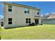 Exterior view of a house with a well-maintained backyard, featuring a cozy seating area at 6780 Coral Berry Dr, Mount Dora, FL 32757