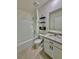 Bright bathroom with a granite countertop vanity, tiled floors, and combined shower and tub at 6780 Coral Berry Dr, Mount Dora, FL 32757
