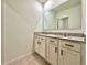 Bathroom vanity features dual sinks with granite countertop, white cabinets, and a large mirror at 6780 Coral Berry Dr, Mount Dora, FL 32757