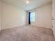 Cozy bedroom with neutral carpet, window with blinds, and a standard closet door at 6780 Coral Berry Dr, Mount Dora, FL 32757