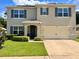 Charming two-story home featuring a well-manicured lawn and a convenient two-car garage at 6780 Coral Berry Dr, Mount Dora, FL 32757