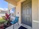 Inviting front entrance with a gray front door, dark shutters, and decorative plants at 6780 Coral Berry Dr, Mount Dora, FL 32757