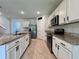 Modern kitchen with white cabinetry, granite countertops, and stainless steel appliances at 6780 Coral Berry Dr, Mount Dora, FL 32757