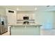 Open kitchen features an island with granite countertop and stainless steel appliances at 6780 Coral Berry Dr, Mount Dora, FL 32757