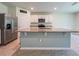 Open concept kitchen with a granite island, stainless steel appliances, and white cabinets at 6780 Coral Berry Dr, Mount Dora, FL 32757