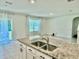 Open-concept kitchen with granite countertops and island providing views into the living spaces at 6780 Coral Berry Dr, Mount Dora, FL 32757