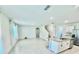 Bright, open-concept living area with tiled flooring and a modern kitchen with granite countertops at 6780 Coral Berry Dr, Mount Dora, FL 32757