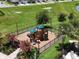 Fenced playground with modern equipment and surrounding landscaping at 6780 Coral Berry Dr, Mount Dora, FL 32757