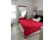 Bedroom with red comforter, tufted headboard, and statement mirror at 7561 Colbury Ave, Windermere, FL 34786
