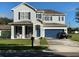 Charming two-story home featuring a manicured lawn, rocking-chair porch, and attached two-car garage at 7561 Colbury Ave, Windermere, FL 34786