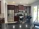 Modern kitchen features stainless steel appliances, dark cabinets, and a granite countertop at 7561 Colbury Ave, Windermere, FL 34786