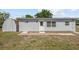 Backyard view of home featuring a back door and window details at 7701 Cassino Ave, Orlando, FL 32819