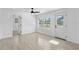 Bright bedroom with wood-look tile flooring, large window, and exterior access at 7701 Cassino Ave, Orlando, FL 32819