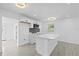 Modern kitchen features white cabinets, quartz island with pendant lights, and stainless steel appliances at 7701 Cassino Ave, Orlando, FL 32819