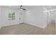 Modern living space with white walls, wood look floors, large window, and front door views at 7701 Cassino Ave, Orlando, FL 32819