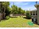 Grassy fenced backyard with mature trees, a/c unit and green garden hose visible at 815 W Yale St, Orlando, FL 32804