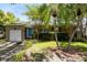 Charming home featuring a manicured lawn, palm trees, and a bright blue front door at 815 W Yale St, Orlando, FL 32804