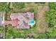 An aerial view of a house with a unique roof and a beautiful pool and backyard space at 9729 Lake Hugh Dr, Gotha, FL 34734