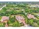 Aerial view showcasing the home's location amidst lush greenery, with a glimpse of a nearby lake and surrounding residential area at 9729 Lake Hugh Dr, Gotha, FL 34734