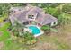 Aerial view showcasing the home's beautiful pool, jacuzzi, mature trees, and lush landscaping, creating a private backyard retreat at 9729 Lake Hugh Dr, Gotha, FL 34734